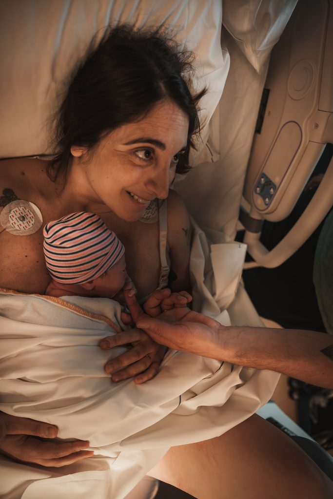 Mother holding her newborn daughter in the hospital bed, birth at the AMC Amsterdam with doula support