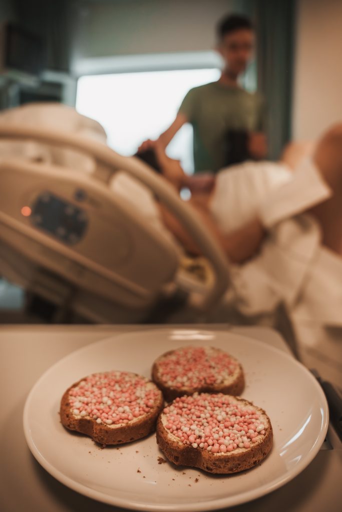 Father with a plate of beschuit met muisjes to celebrate the birth, birth at the AMC Amsterdam with doula support