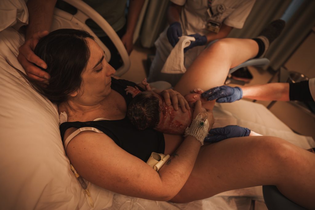 Mother breastfeeding her newborn for the first time in the hospital, birth at the AMC Amsterdam with doula support