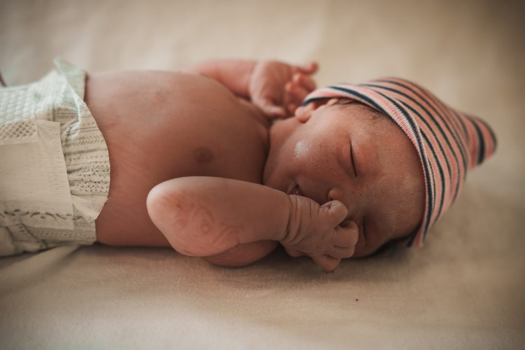 Newborn baby lying on the hospital blanket in soft light, birth at the AMC Amsterdam with doula support