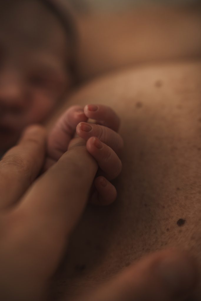 Newborn feet held in her mother's hand right after birth, birth at the AMC Amsterdam with doula support