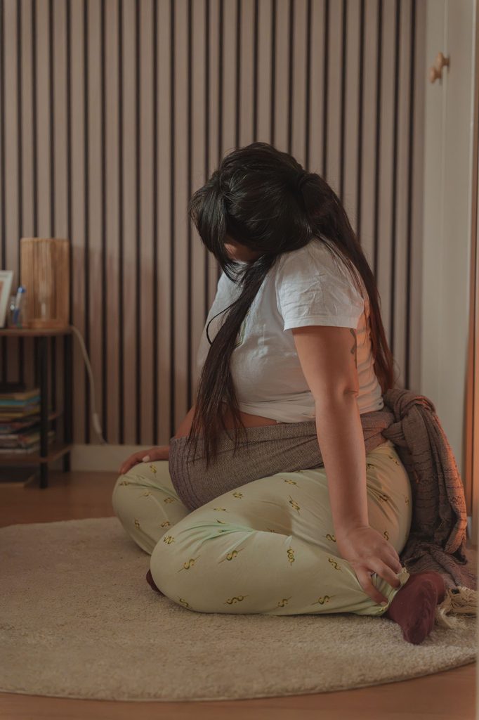 Mother kneeling on a cushion at home, moving to help her baby come down, doula support at a hospital birth in Arnhem