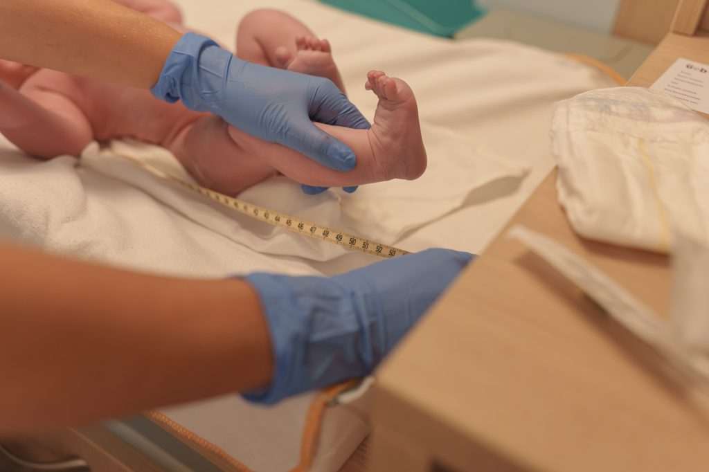 Newborn baby feet checked by the midwife after birth, doula support at a hospital birth in Arnhem