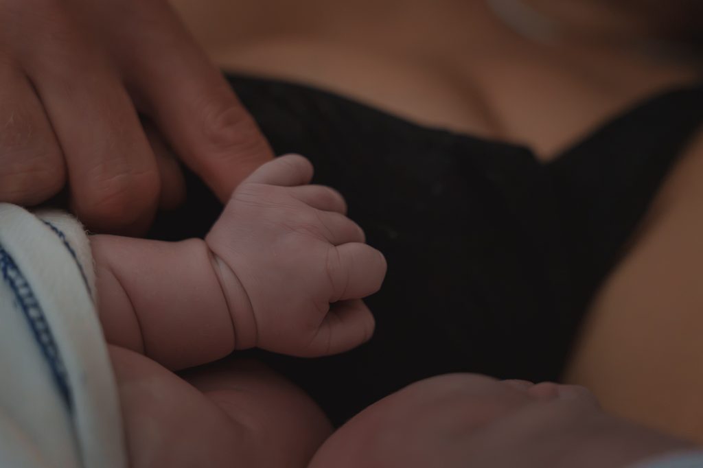 Newborn tiny hand on mother's chest, doula support at a hospital birth in Arnhem