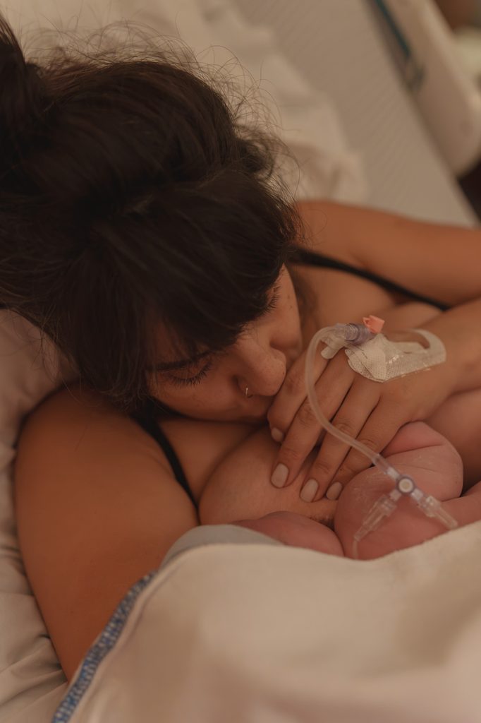 Mother holding her newborn daughter close right after birth, doula support at a hospital birth in Arnhem